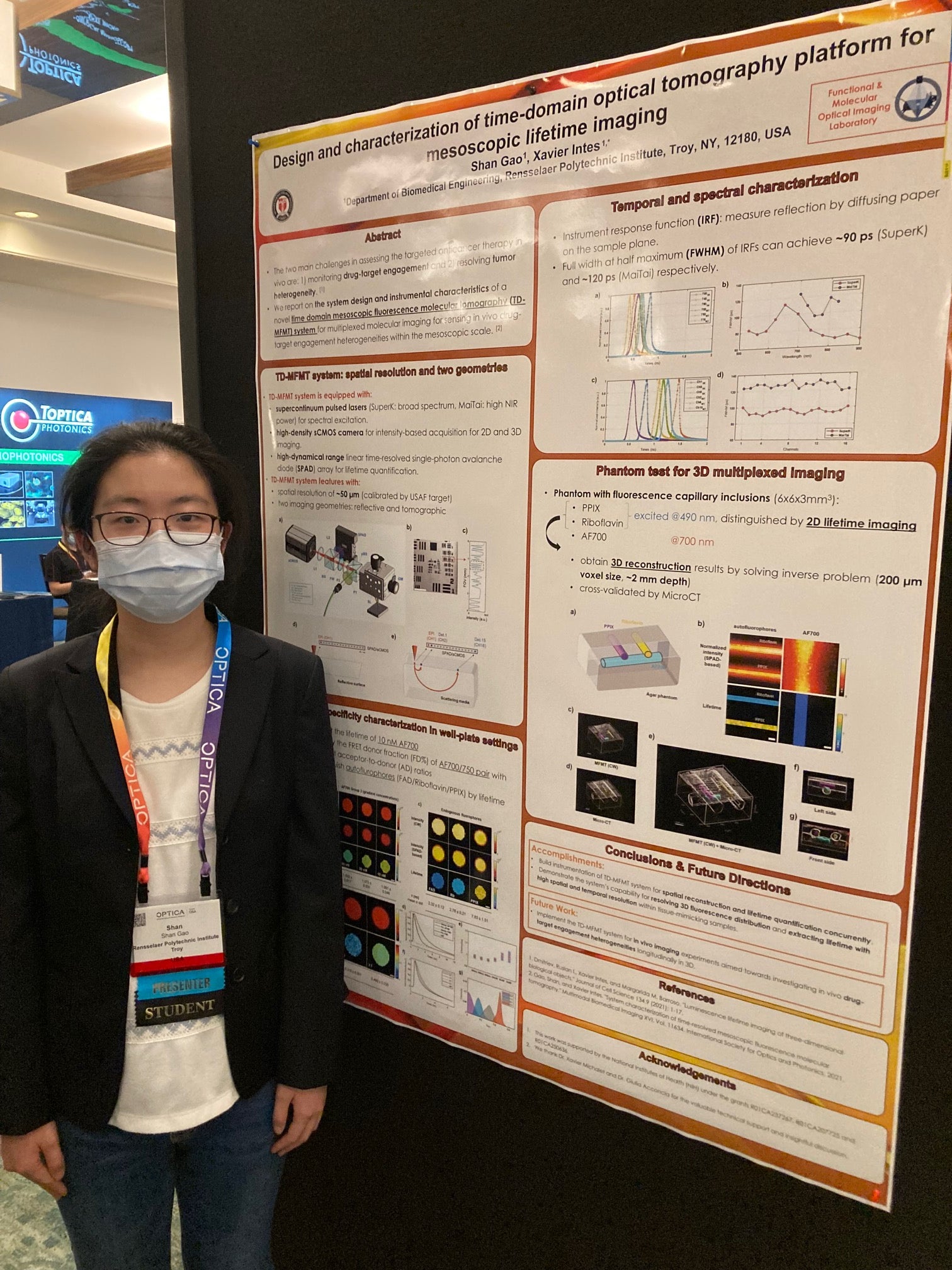 Shan Gao, standing beside her poster at the OSA 2021 conference.